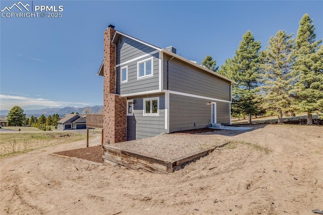1120 Lake Woodmoor Dr, Monument, CO 80132 - rear view of house featuring a chimney and a mountain view