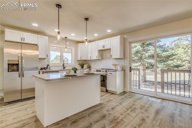 1120 Lake Woodmoor Dr, Monument, CO 80132 - kitchen with tasteful backsplash, light wood-style floors, and appliances with stainless steel finishes