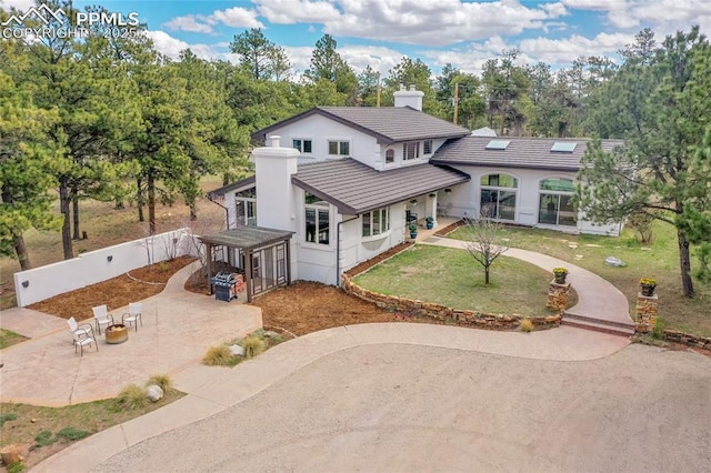 17350 Goshawk Rd, Colorado Springs, CO 80908 - view of front of property featuring a front lawn, fence, a chimney, a patio area, and driveway