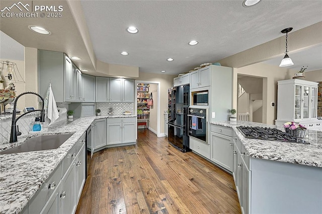 17350 Goshawk Rd, Colorado Springs, CO 80908 - kitchen featuring a sink, recessed lighting, a peninsula, wood finished floors, and black appliances
