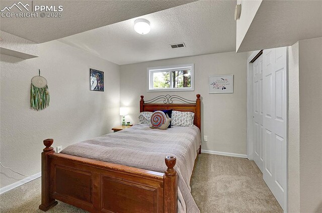 17350 Goshawk Rd, Colorado Springs, CO 80908 - bedroom with a textured ceiling, baseboards, visible vents, and light carpet