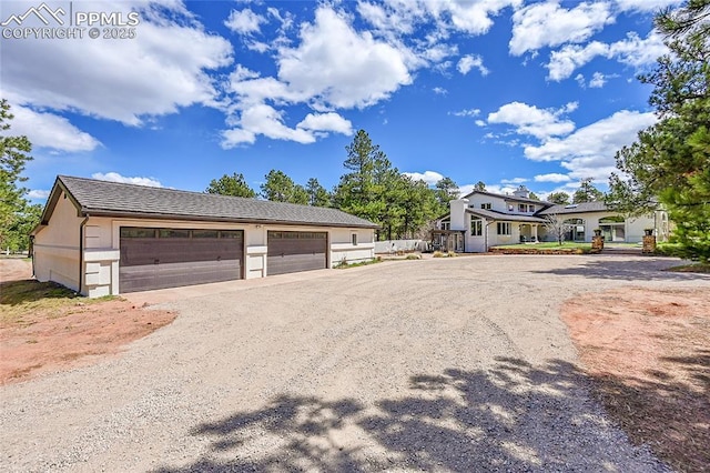 17350 Goshawk Rd, Colorado Springs, CO 80908 - view of front of home featuring a garage, an outbuilding, stucco siding, and driveway