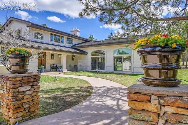 17350 Goshawk Rd, Colorado Springs, CO 80908 - back of property with stucco siding, a yard, and a chimney