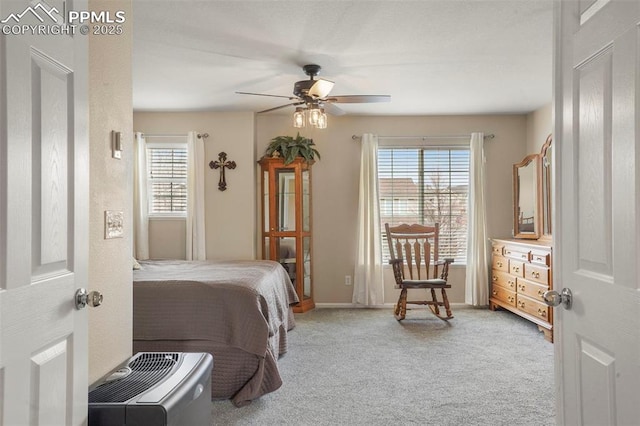 carpeted bedroom featuring baseboards, a ceiling fan, and multiple windows