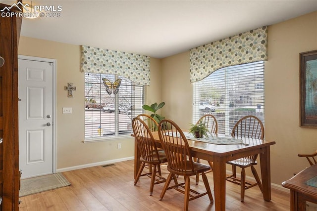 dining area featuring baseboards, plenty of natural light, and light wood-style floors