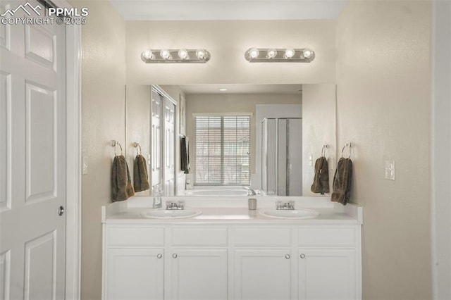 bathroom with a sink, double vanity, a stall shower, and a garden tub