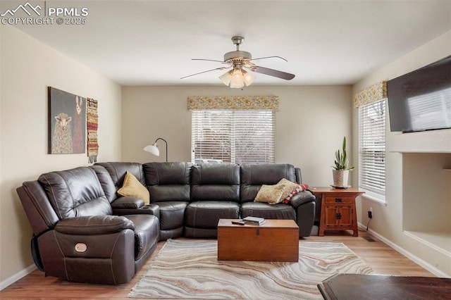 living room with baseboards, a ceiling fan, and wood finished floors