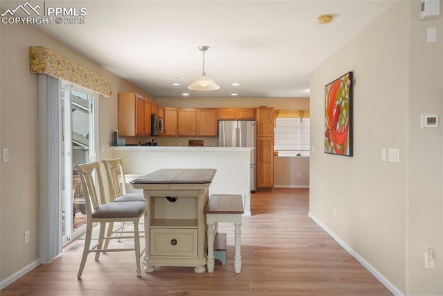 kitchen with a kitchen breakfast bar, stainless steel appliances, baseboards, recessed lighting, and light wood-type flooring