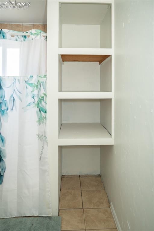1015 5th St, Del Norte, CO 81132 - bathroom with a shower with shower curtain and tile patterned floors