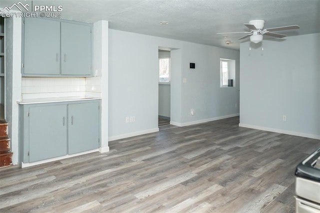 1015 5th St, Del Norte, CO 81132 - unfurnished living room featuring baseboards, a ceiling fan, and wood finished floors