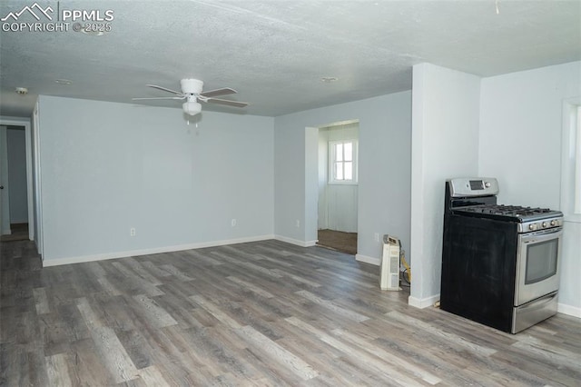 1015 5th St, Del Norte, CO 81132 - unfurnished living room with baseboards, a ceiling fan, wood finished floors, and a textured ceiling