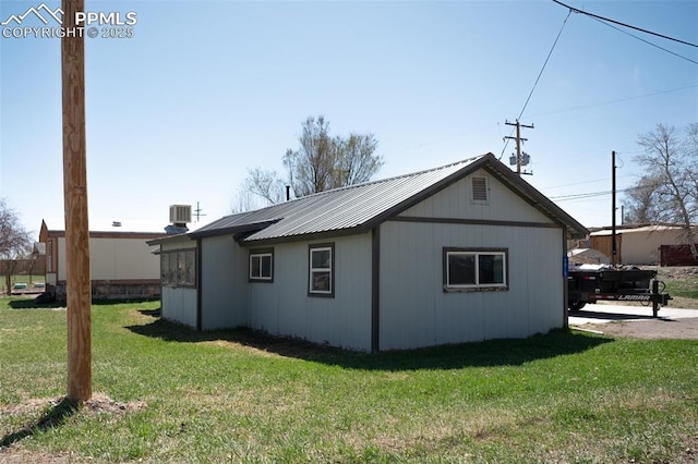 1015 5th St, Del Norte, CO 81132 - view of side of property featuring a lawn, cooling unit, and metal roof