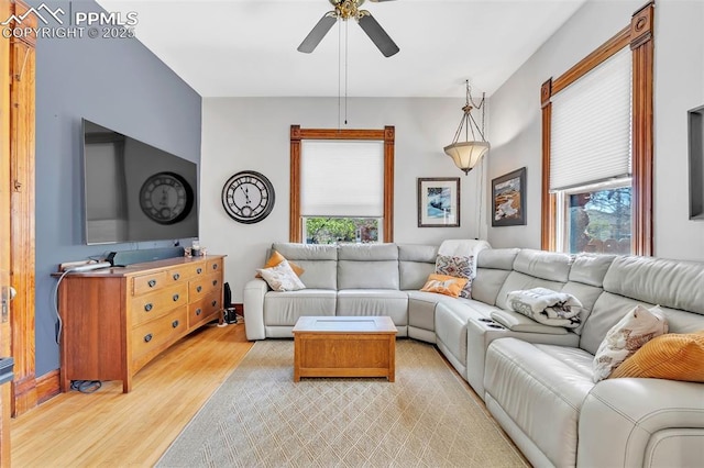 living area featuring light wood-style floors, a wealth of natural light, and a ceiling fan