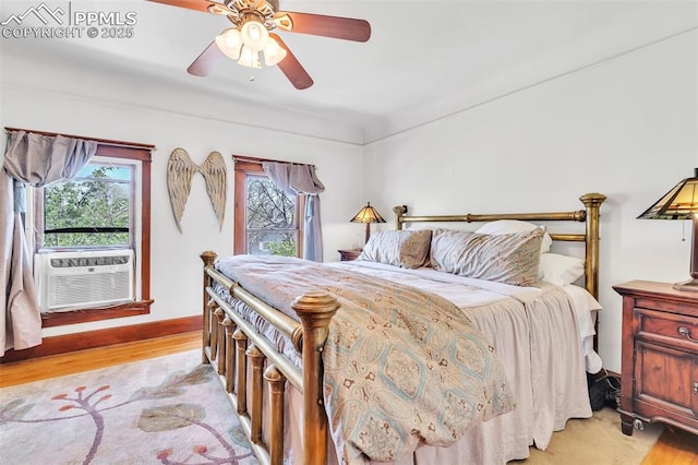 bedroom with light wood-style flooring, cooling unit, and ceiling fan