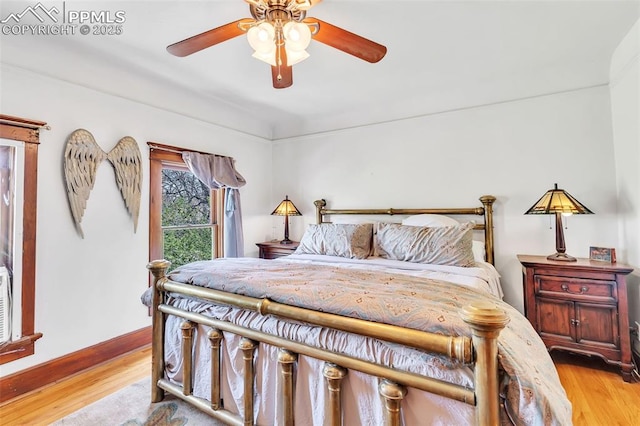 bedroom with ceiling fan, baseboards, and light wood finished floors