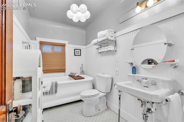 bathroom featuring a bath, tile patterned flooring, and toilet