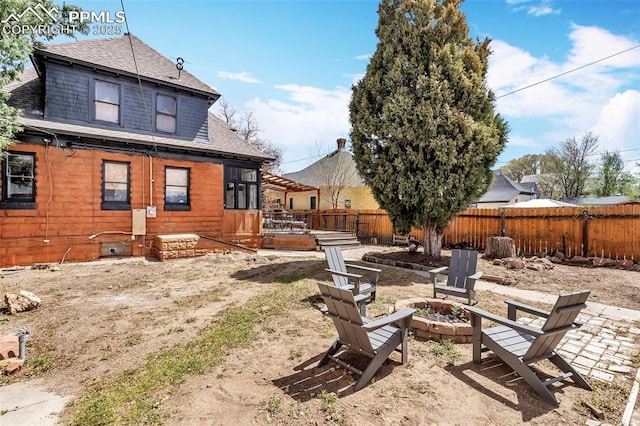 view of yard featuring a wooden deck, a fenced backyard, and a fire pit