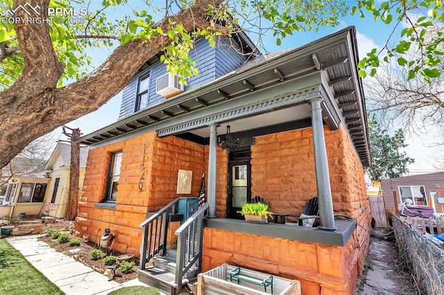 back of property featuring fence and covered porch