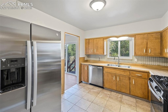 621 Rowe Ln, Colorado Springs, CO 80911 - kitchen with light countertops, brown cabinetry, a sink, and stainless steel appliances