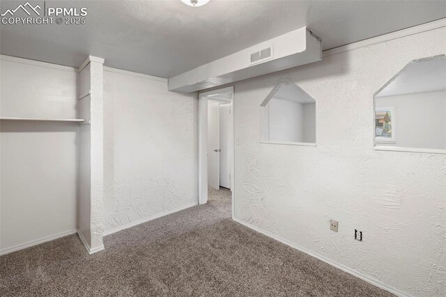621 Rowe Ln, Colorado Springs, CO 80911 - finished basement featuring visible vents, baseboards, a textured wall, and carpet floors