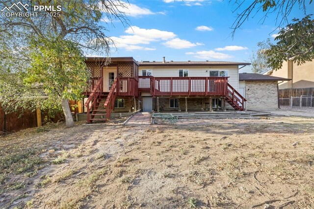 621 Rowe Ln, Colorado Springs, CO 80911 - rear view of house featuring a wooden deck, fence, and stairway