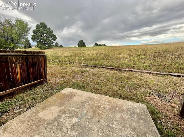 1154 Darby St, Colorado Springs, CO 80907 - view of yard with a patio, a view of countryside, and fence