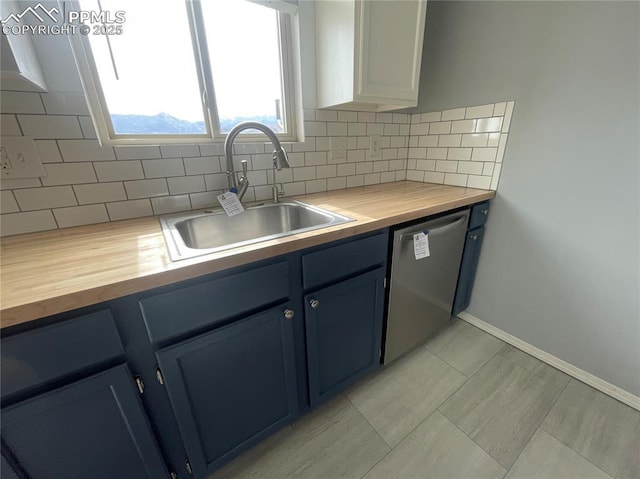 1426 Territory Trl, Colorado Springs, CO 80919 - kitchen featuring blue cabinetry, dishwasher, a sink, butcher block countertops, and decorative backsplash