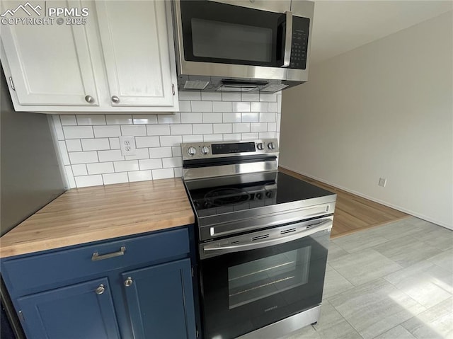1426 Territory Trl, Colorado Springs, CO 80919 - kitchen featuring butcher block counters, blue cabinetry, backsplash, and stainless steel appliances