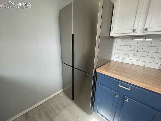 1426 Territory Trl, Colorado Springs, CO 80919 - kitchen featuring baseboards, freestanding refrigerator, backsplash, wooden counters, and blue cabinets