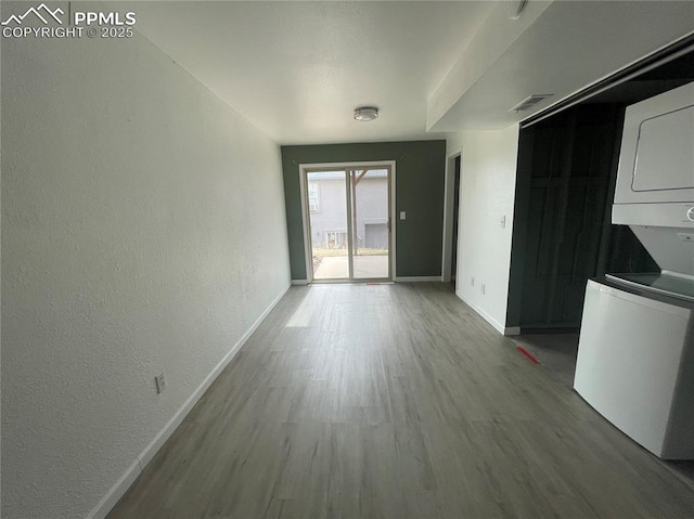 1426 Territory Trl, Colorado Springs, CO 80919 - unfurnished dining area with a textured wall, stacked washer / dryer, baseboards, and wood finished floors