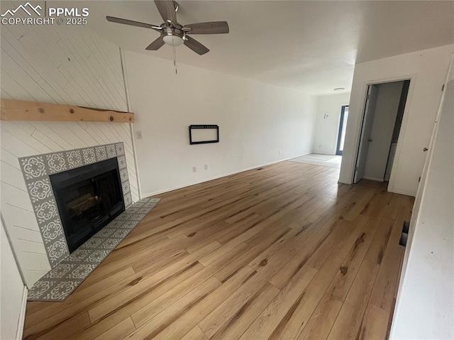 1426 Territory Trl, Colorado Springs, CO 80919 - unfurnished living room with a tiled fireplace, ceiling fan, baseboards, and wood finished floors