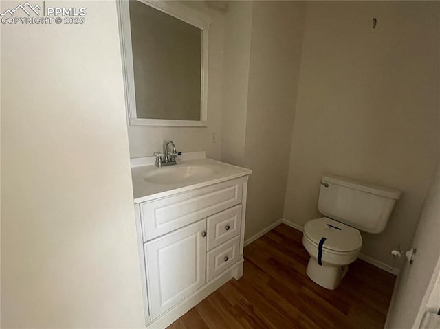 1426 Territory Trl, Colorado Springs, CO 80919 - bathroom featuring toilet, vanity, wood finished floors, and baseboards