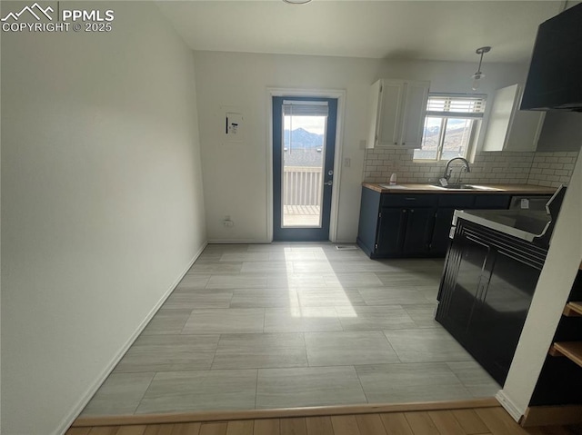 1426 Territory Trl, Colorado Springs, CO 80919 - kitchen with tasteful backsplash, baseboards, light countertops, white cabinets, and a sink