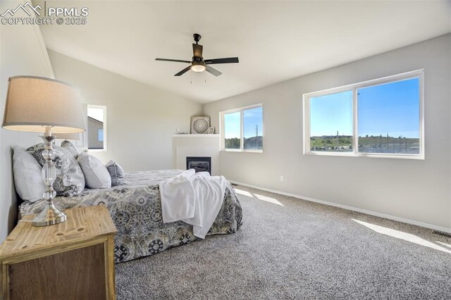 5717 Stable Ct, Colorado Springs, CO 80920 - carpeted bedroom with baseboards, a tiled fireplace, vaulted ceiling, and a ceiling fan