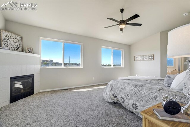 5717 Stable Ct, Colorado Springs, CO 80920 - bedroom featuring carpet flooring, a tile fireplace, baseboards, vaulted ceiling, and ceiling fan