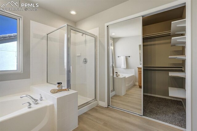 5717 Stable Ct, Colorado Springs, CO 80920 - full bathroom featuring a bath, a stall shower, wood finished floors, recessed lighting, and baseboards