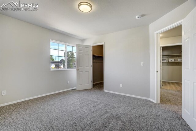 5717 Stable Ct, Colorado Springs, CO 80920 - unfurnished bedroom featuring carpet, a walk in closet, and baseboards
