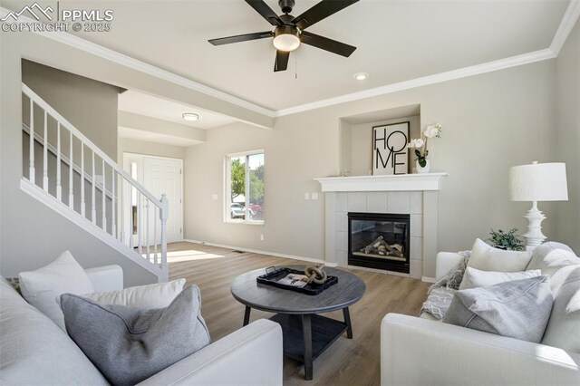 5717 Stable Ct, Colorado Springs, CO 80920 - living room with stairs, wood finished floors, a ceiling fan, crown molding, and baseboards