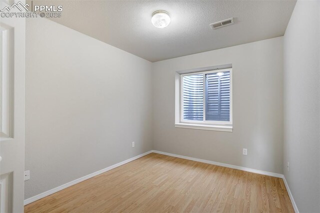 5717 Stable Ct, Colorado Springs, CO 80920 - spare room featuring wood finished floors, baseboards, and a textured ceiling