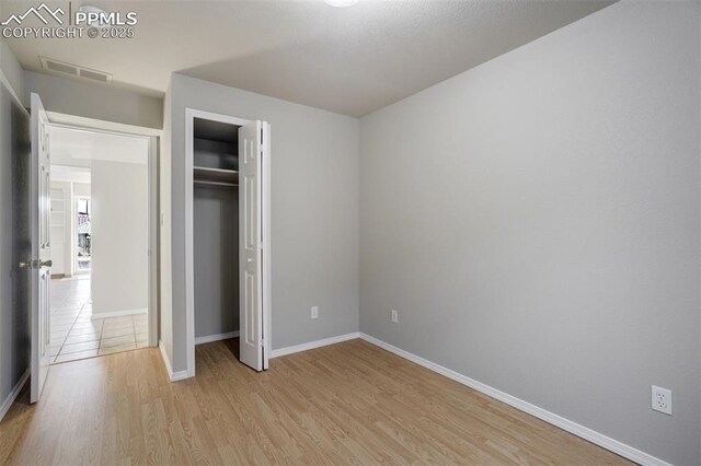 5717 Stable Ct, Colorado Springs, CO 80920 - unfurnished bedroom with light wood-style floors, baseboards, and a closet
