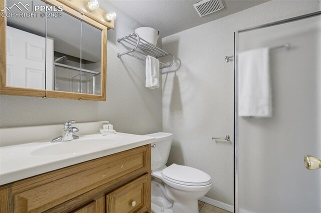 5717 Stable Ct, Colorado Springs, CO 80920 - full bathroom featuring vanity, a shower with door, toilet, and tile patterned flooring