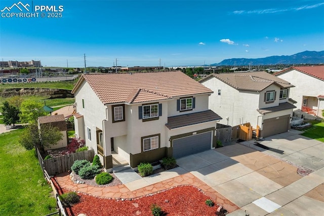5717 Stable Ct, Colorado Springs, CO 80920 - view of front of house with an attached garage, stucco siding, driveway, and a mountain view