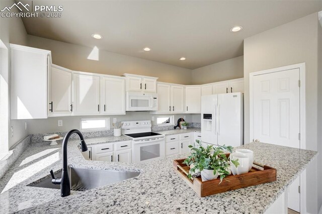 5717 Stable Ct, Colorado Springs, CO 80920 - kitchen featuring white appliances, a sink, white cabinets, light stone counters, and recessed lighting