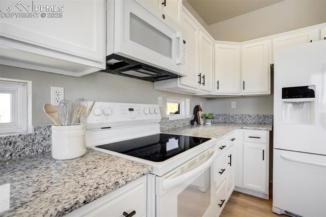 5717 Stable Ct, Colorado Springs, CO 80920 - kitchen featuring white appliances, white cabinets, light stone countertops, and light wood-type flooring