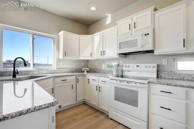 5717 Stable Ct, Colorado Springs, CO 80920 - kitchen featuring white appliances, a sink, white cabinets, light wood-style flooring, and light stone countertops