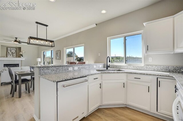 5717 Stable Ct, Colorado Springs, CO 80920 - kitchen featuring a sink, a ceiling fan, light wood finished floors, open floor plan, and white cabinets