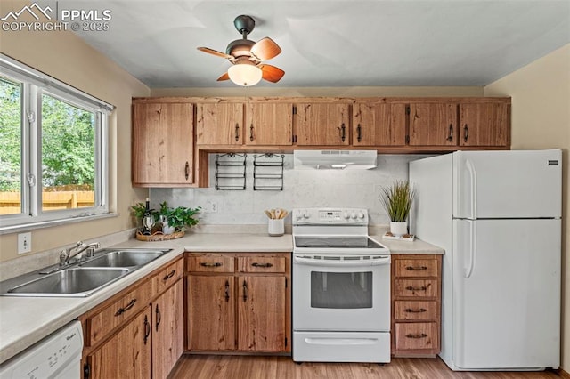 930 Bowser Dr, Colorado Springs, CO 80909 - kitchen featuring white appliances, ventilation hood, a sink, and light countertops