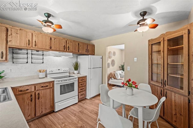 930 Bowser Dr, Colorado Springs, CO 80909 - kitchen with white appliances, a ceiling fan, light countertops, light wood-style flooring, and under cabinet range hood