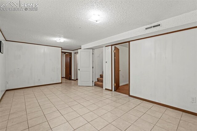 930 Bowser Dr, Colorado Springs, CO 80909 - finished below grade area with a textured ceiling, stairs, and baseboards