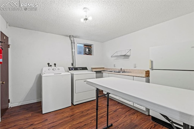 930 Bowser Dr, Colorado Springs, CO 80909 - washroom featuring washer and clothes dryer, dark wood-style floors, a textured ceiling, cabinet space, and baseboards